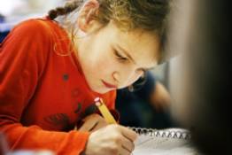 Decoratieve afbeelding: Een meisje aan het werk op school