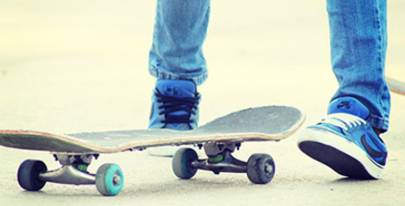 Skateboard en de benen van een puber met sneakers