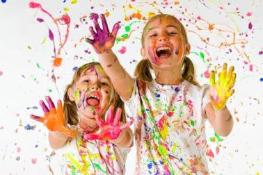 Decoratieve afbeelding: 2 kinderen zitten onder de verfspetters en steken 5 vingers op